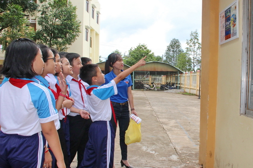 Các em học sinh trường THCS Tân Phú vui vẻ hưởng ứng với tấm bảng tuyên truyền Tiết kiệm điện.
